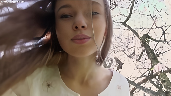 18ти летняя шатенка с длинными волосами и без одежды лазит по дереву в весеннем саду