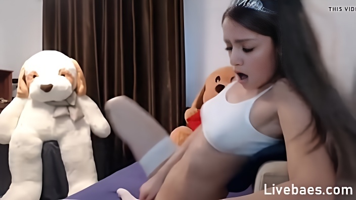 Брюнетка в белой майке и в чулках раздвинула ноги перед камерой и занялась мастурбацией